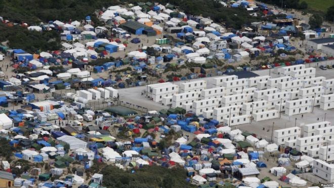 FILE - A makeshift camp of shipping containers and tents houses migrants in the 'jungle,' a sprawling camp at the French port of Calais. Two camps planned in Paris could lead to its dismantling.